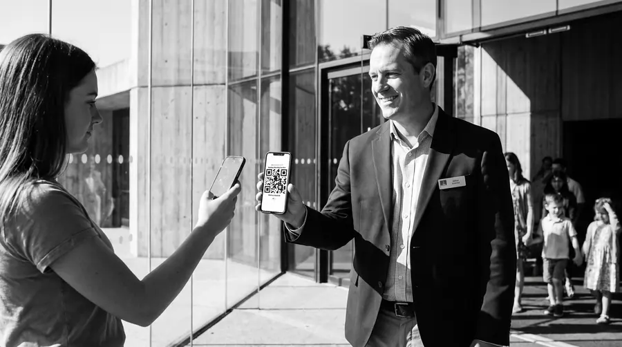 Close-up: a member scans the QR code on an usher's phone